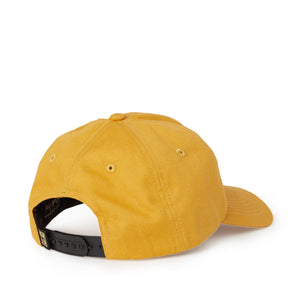 Back view of gold canvas dad hat with black curling wave tag.