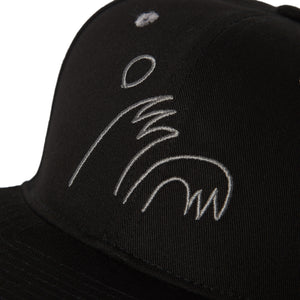 detail view of  black 5 panel snapback cap with 'High Five' curling wave logo in grey. 