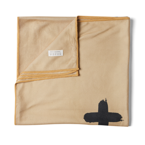 Unsalted & Shark-Free | Tan overhead detail shot of folded microfiber towel with corner folded over showing minimalistic care instructions. 