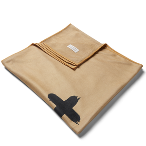 Unsalted & Shark-Free |  detail shot of folded microfiber towel with corner folded over showing minimalistic care instructions and stitching detail. 