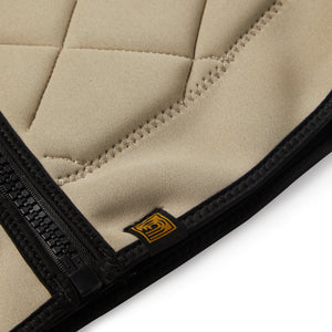 | Tan Tan competition surf vest detail image on white with black YKK zipper and simple logo. 
